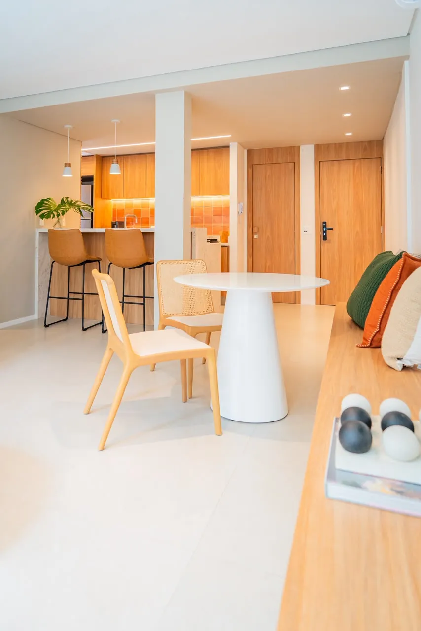 Sala de jantar integrada à cozinha, com portas e banco em madeira